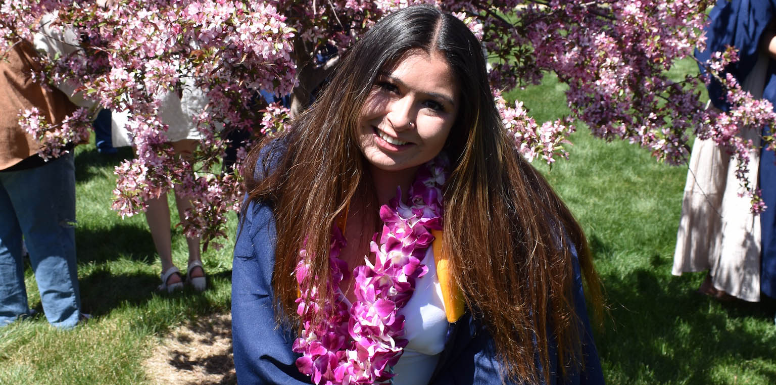 Michelle Sarahang smiles wearing her graduation regalia.