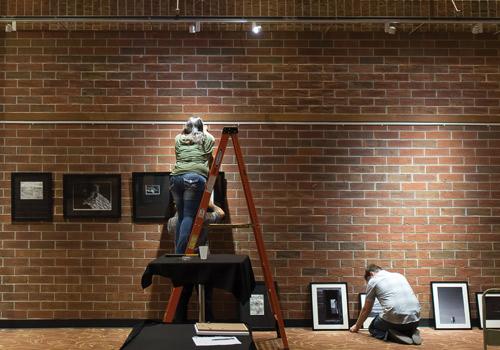  Art and Design students prepare their gallery displays on Friday night in the Two Rivers Lounge. Photo by Woody Myers