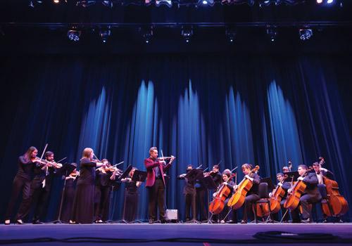 Professor of Viola Christopher Luther performs a solo with the string section.  Photo by Woody Myers