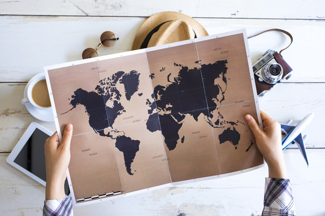 A person holds a map of the world