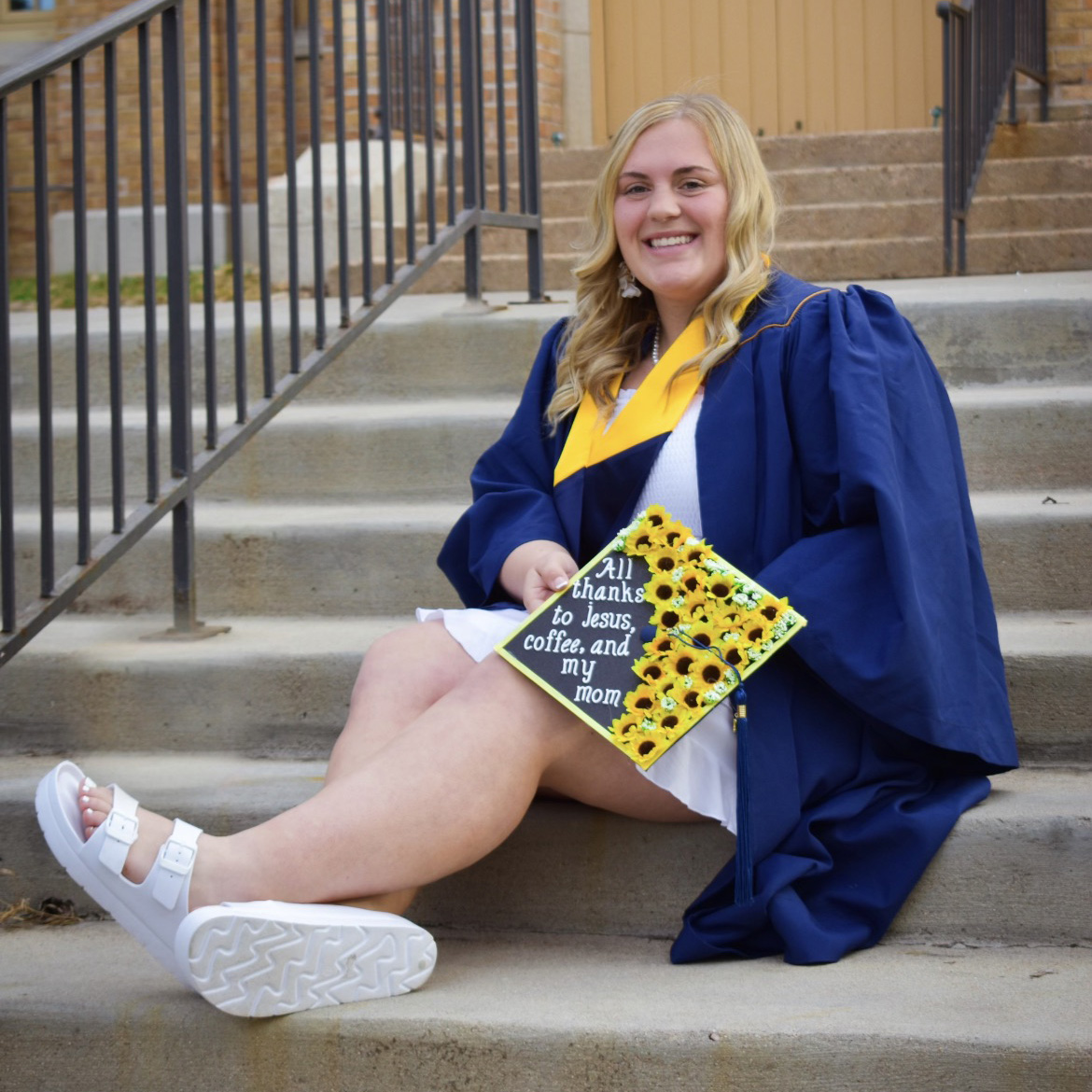 Karlee sitting on steps in her cap and gown