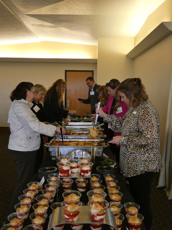 Conference attendees helping themselves to food from a table