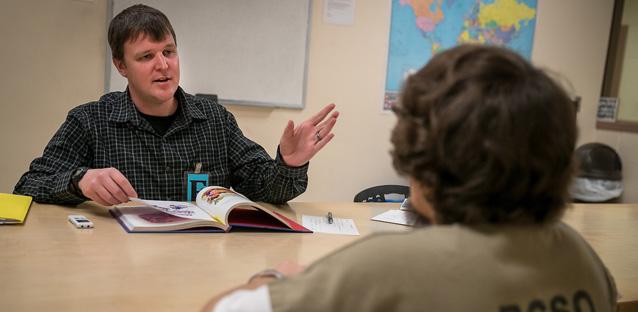 Kyle Ward talks with a Boulder County Jail inmate before they record a children’s book for the inmate’s daughter as part of the “Reading for a Change” program. Photo by Hunter Wilson