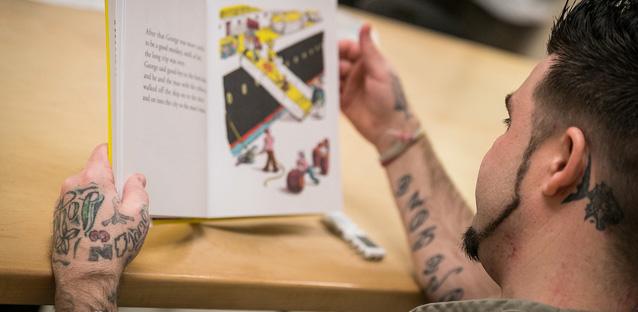 A Boulder County Jail inmate reads a children’s book as part of a study by UNC assistant professor Kyle Ward, who is researching the effects of incarceration and family bonds. Photo by Hunter Wilson
