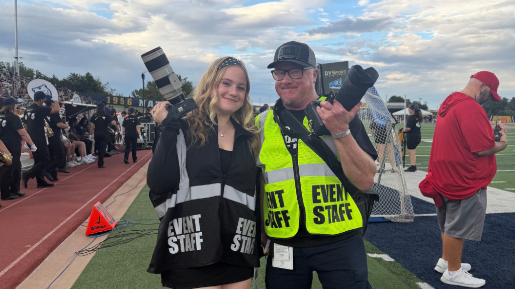 student photographer Lexi Martin on the left standing next to UNC photographer Woody Myers on the right. They are both holding cameras in their hand
