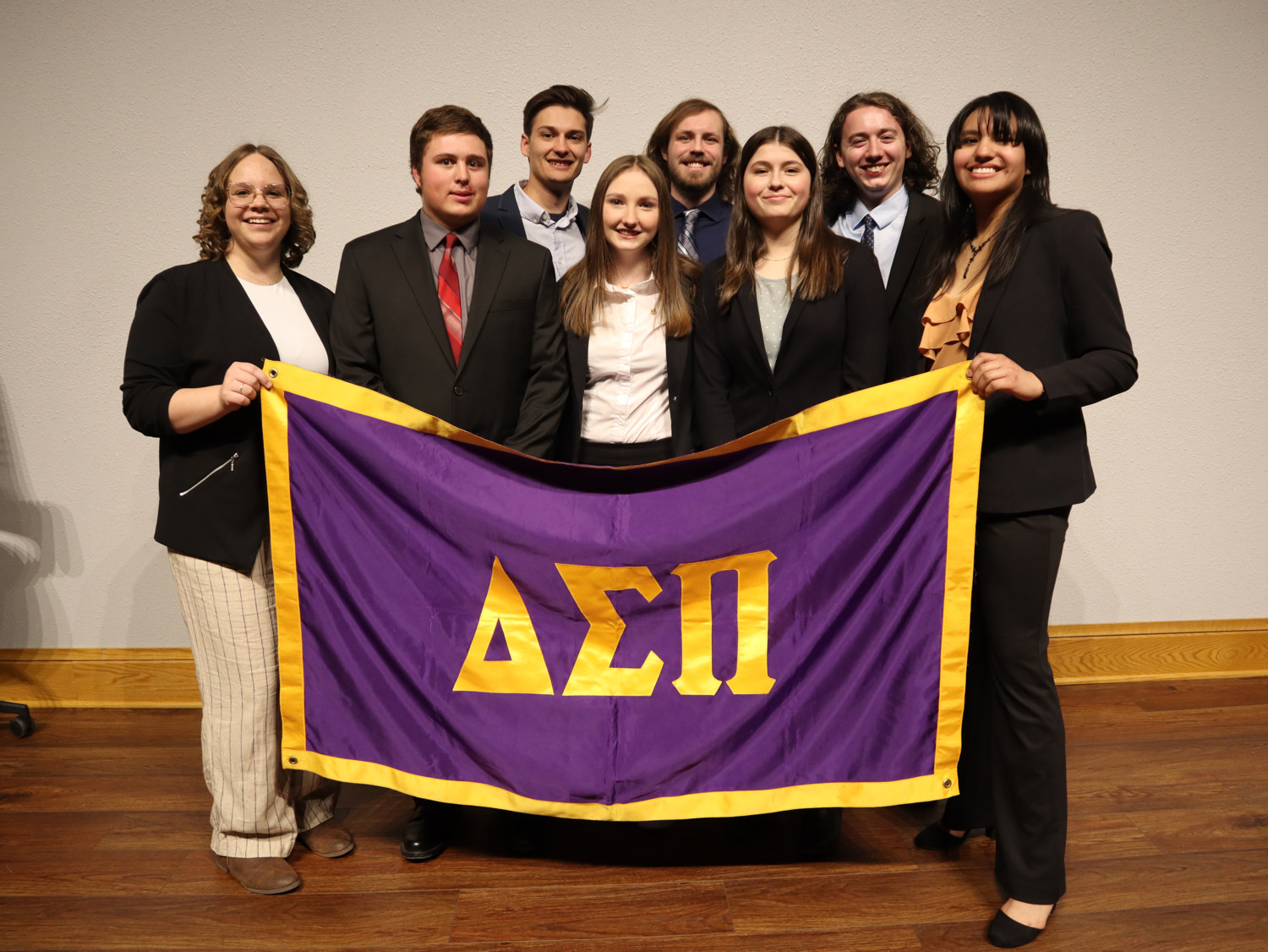 MCb club Delta Sigma Pi holding their club flag.