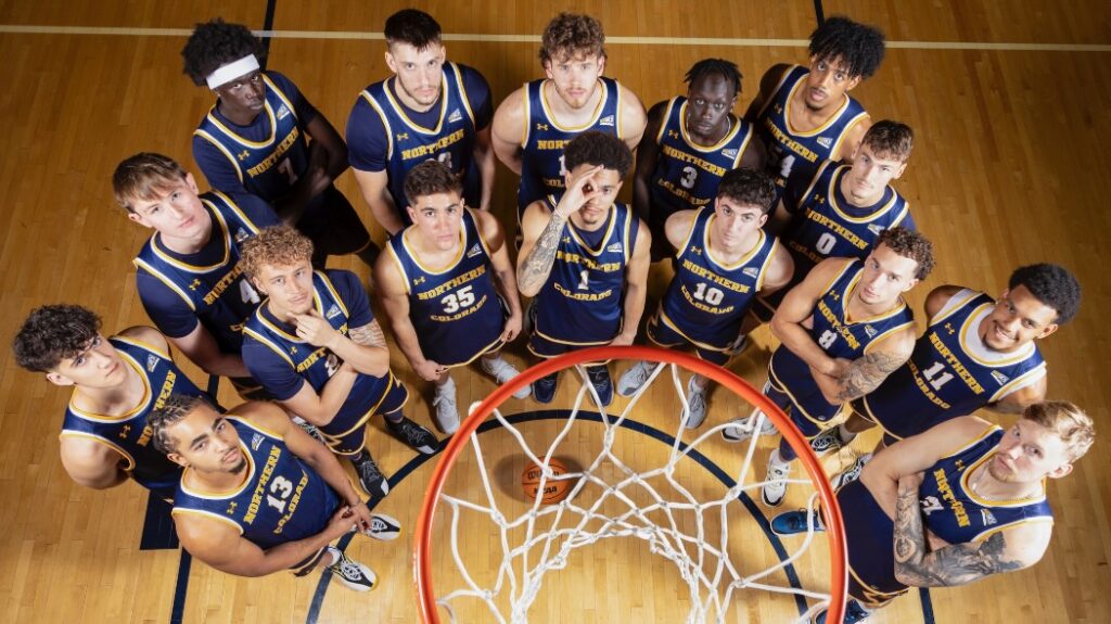 The UNC basketball team looking up at a camera above the basketball net in a group photo