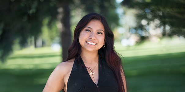 Portrait of Arely Patricio on campus with a green background