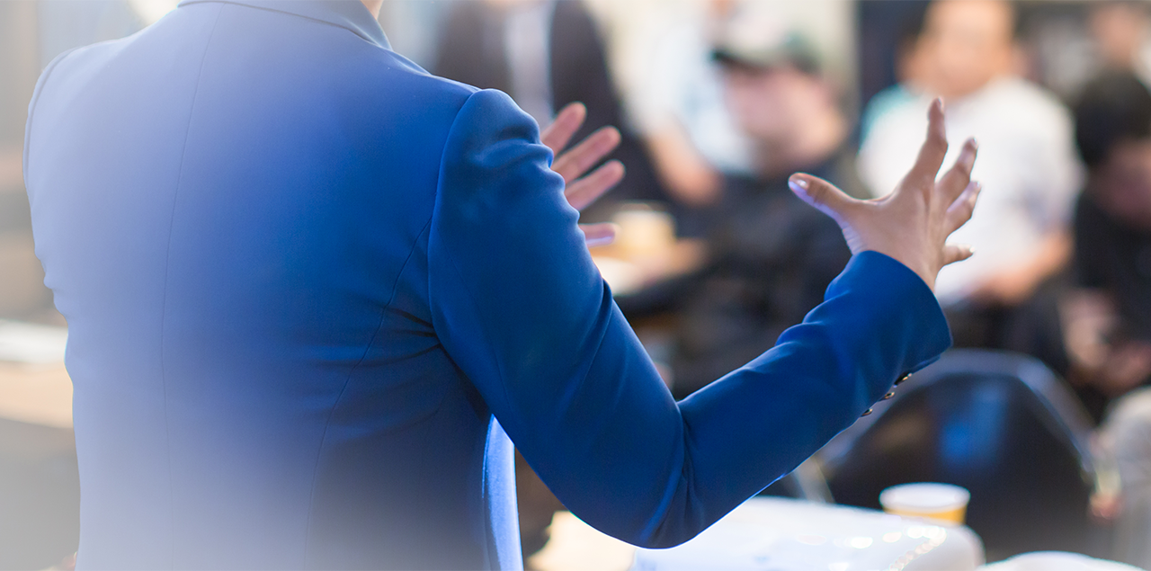 shot of a woman from behind, presenting to a crowd of people