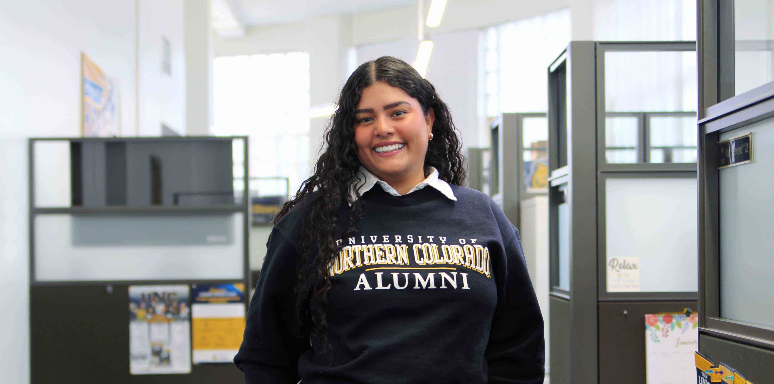 Teresa Castro smiles while standing in her office building.