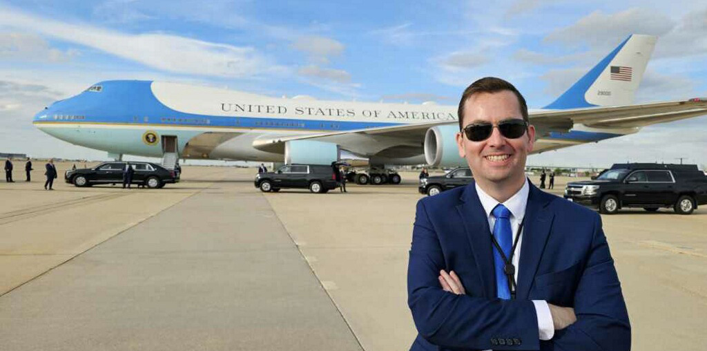 Heath Montgomery, '05, smiles in front of an aircraft.