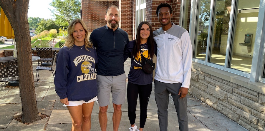Mark & Tammy Berven standing next to two student athletes