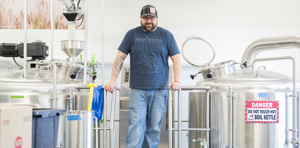 A man standing in front of the inside of a brewery