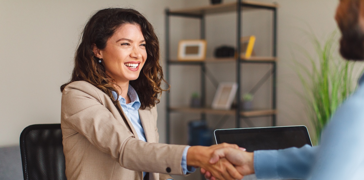 Young woman signing contracts and handshake with a manager