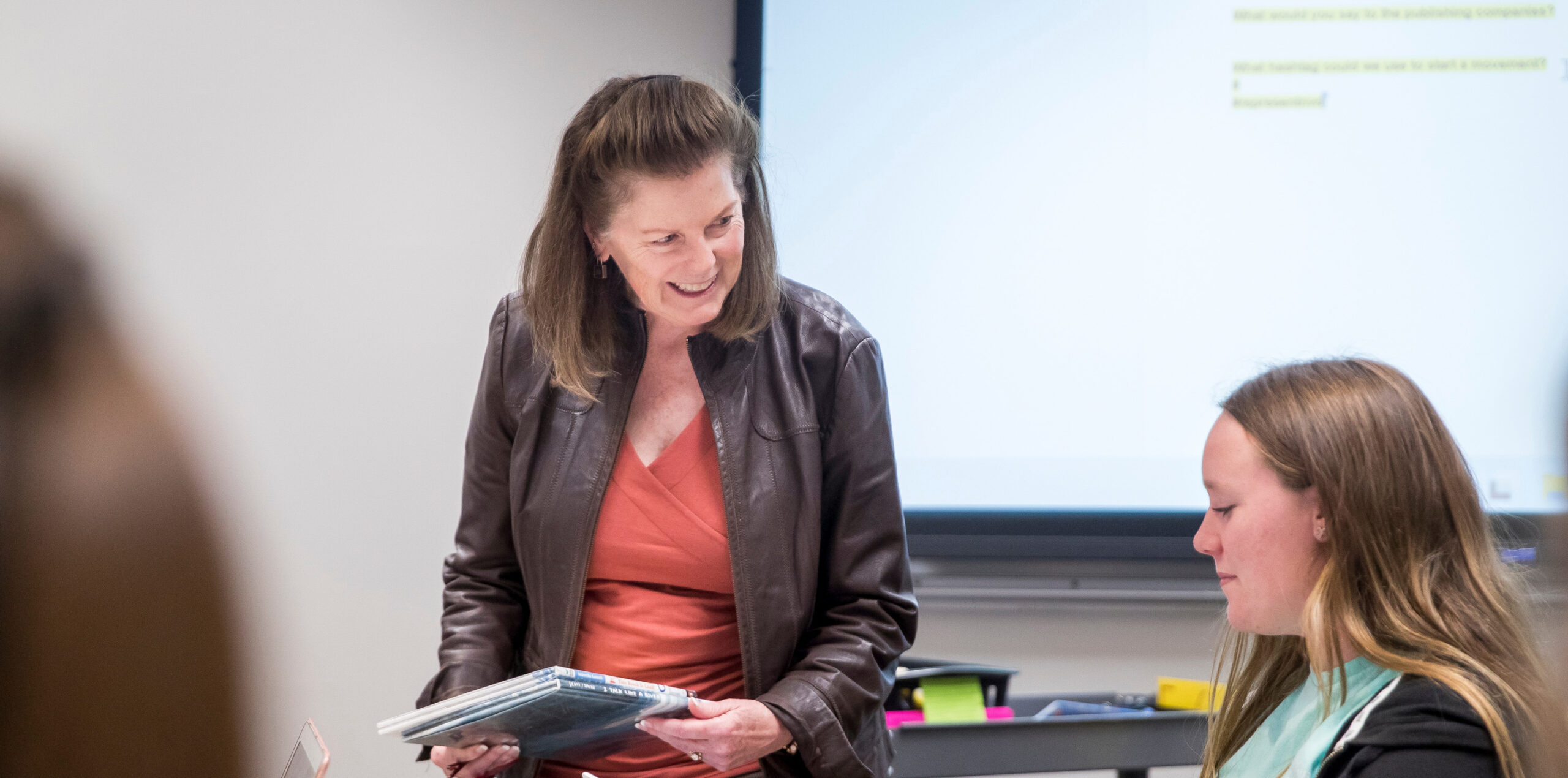 Kathleen Sears talking to a student in a classroom