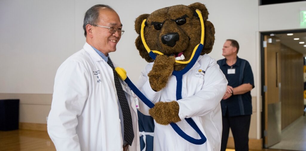 Klawz, the UNC mascot posing with a professor
