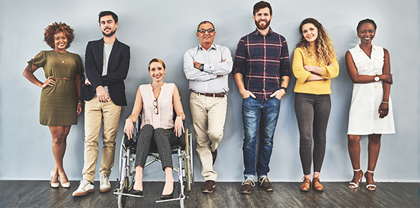 Diverse group of business people standing against a blue wall