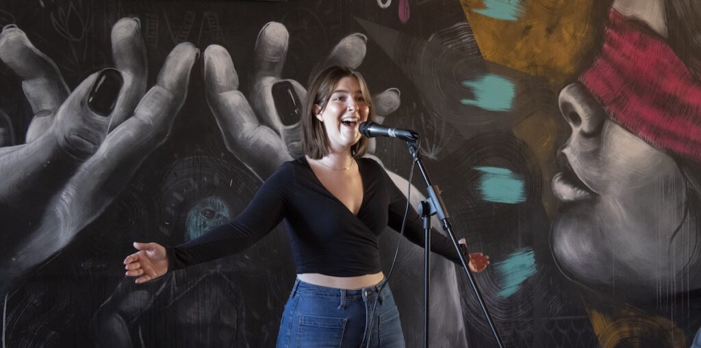 A student singing a song on stage