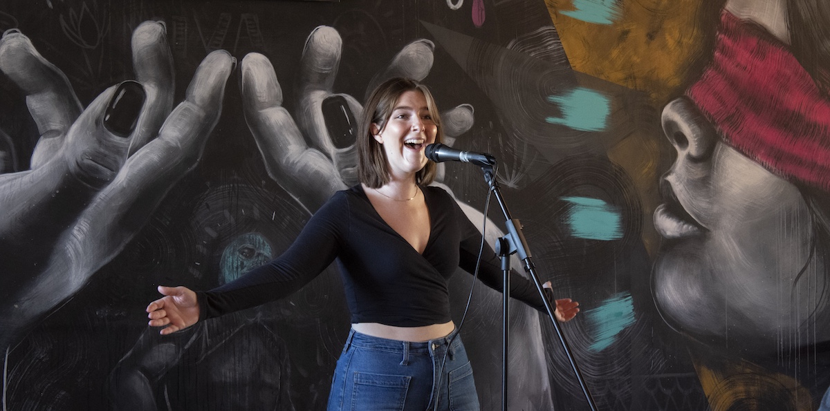 A student singing a song on stage