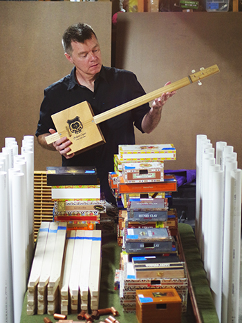Finan holding a cigar-box guitar