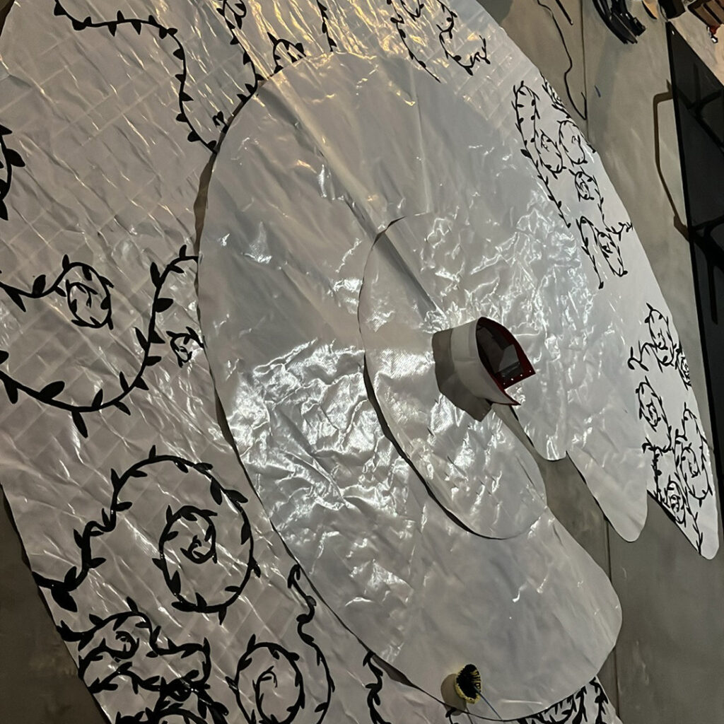 A circle of white duck tape skirt laying on the ground