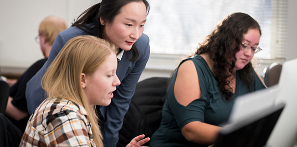 Dr. Park teaching digital art in front of a computer with students