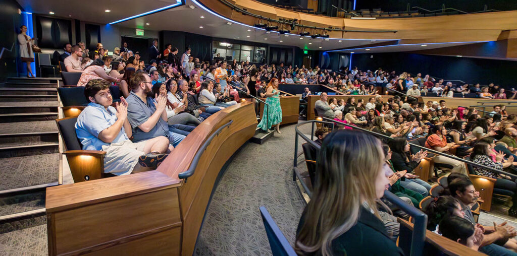 Campus commons performance hall full with families and friends of latine students