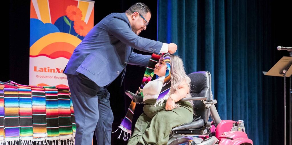 Graduating student in an electric car receiving her sarape stola