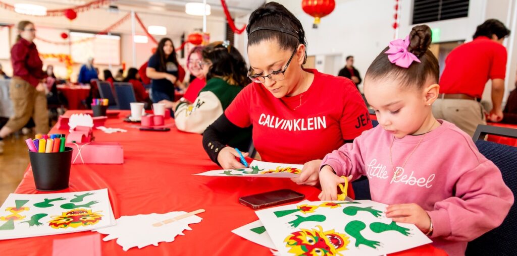 A mom making crafts with her daughter sitting at a table