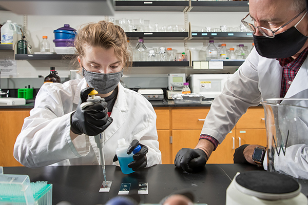 Patrick Burns helping student with research