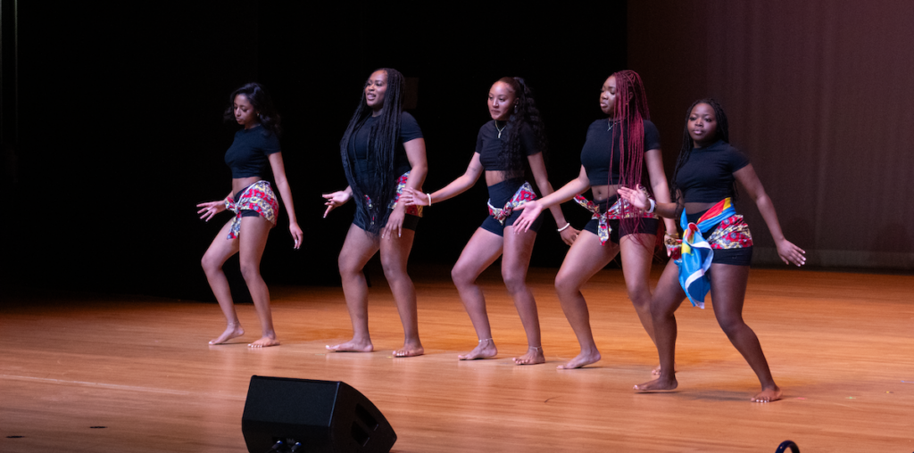 Women dancing together facing a crowd