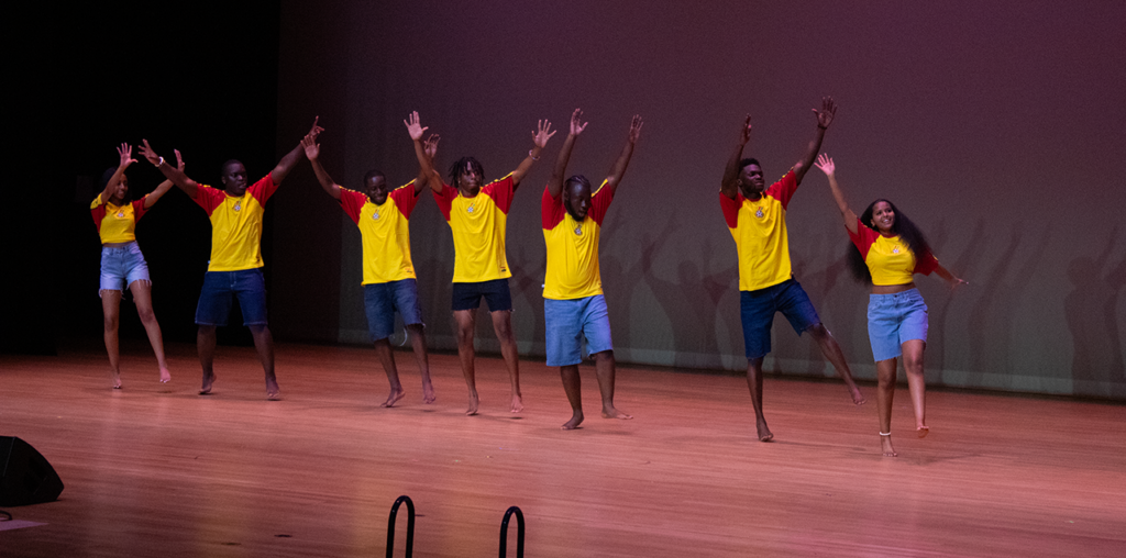 A group of men and women dancing together on stage
