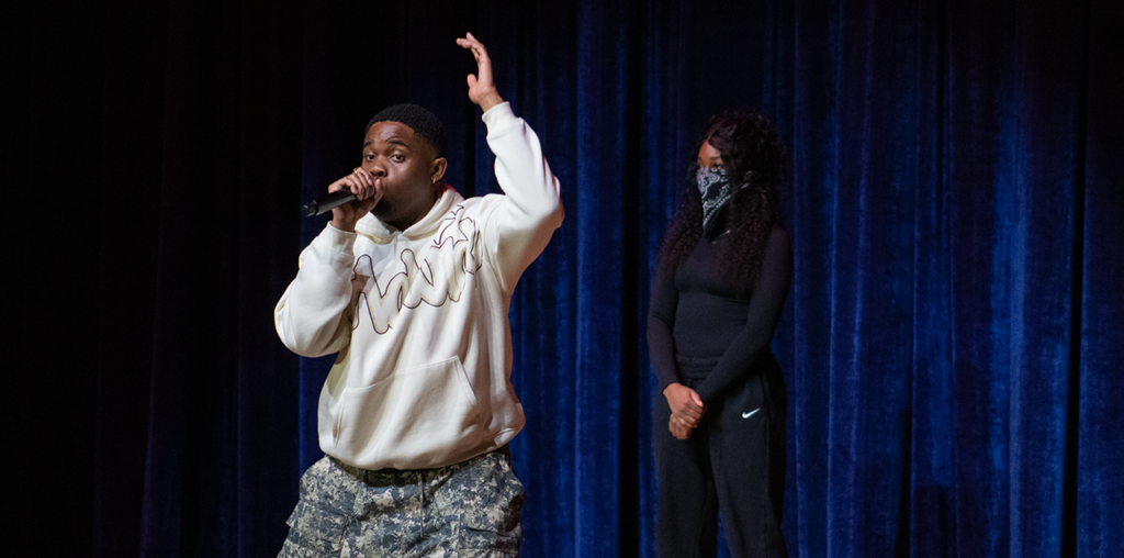 A man holding a microphone to his mouth singing on a stage