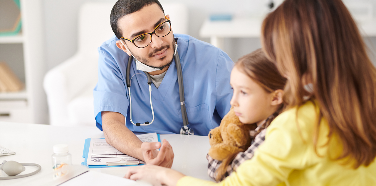 Portrait of a doctor talking to young mother trying to help her and her daughter during consultation.
