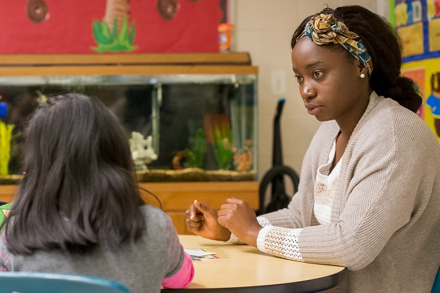 IOC interpreter tutoring a young student
