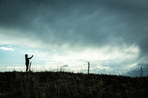 Student recording storm data outside.