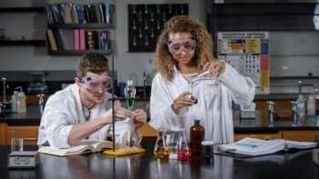 Two students working in chemistry lab on UNC campus.