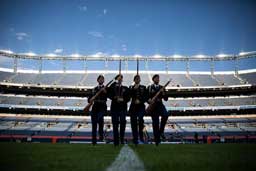 Four ROTC students in a stadium on the field.