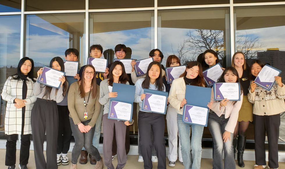 Exchange students holding certificates standing in front of UC