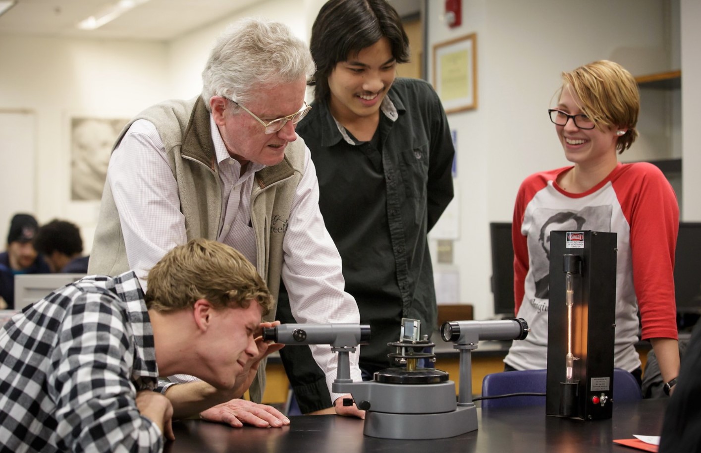 Students and their professor working in the physics lab.