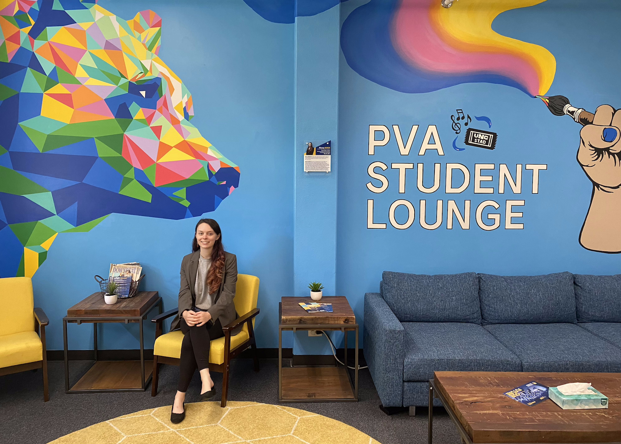 Macey Boren with the mural she designed and painted in Frasier Hall's student lounge.