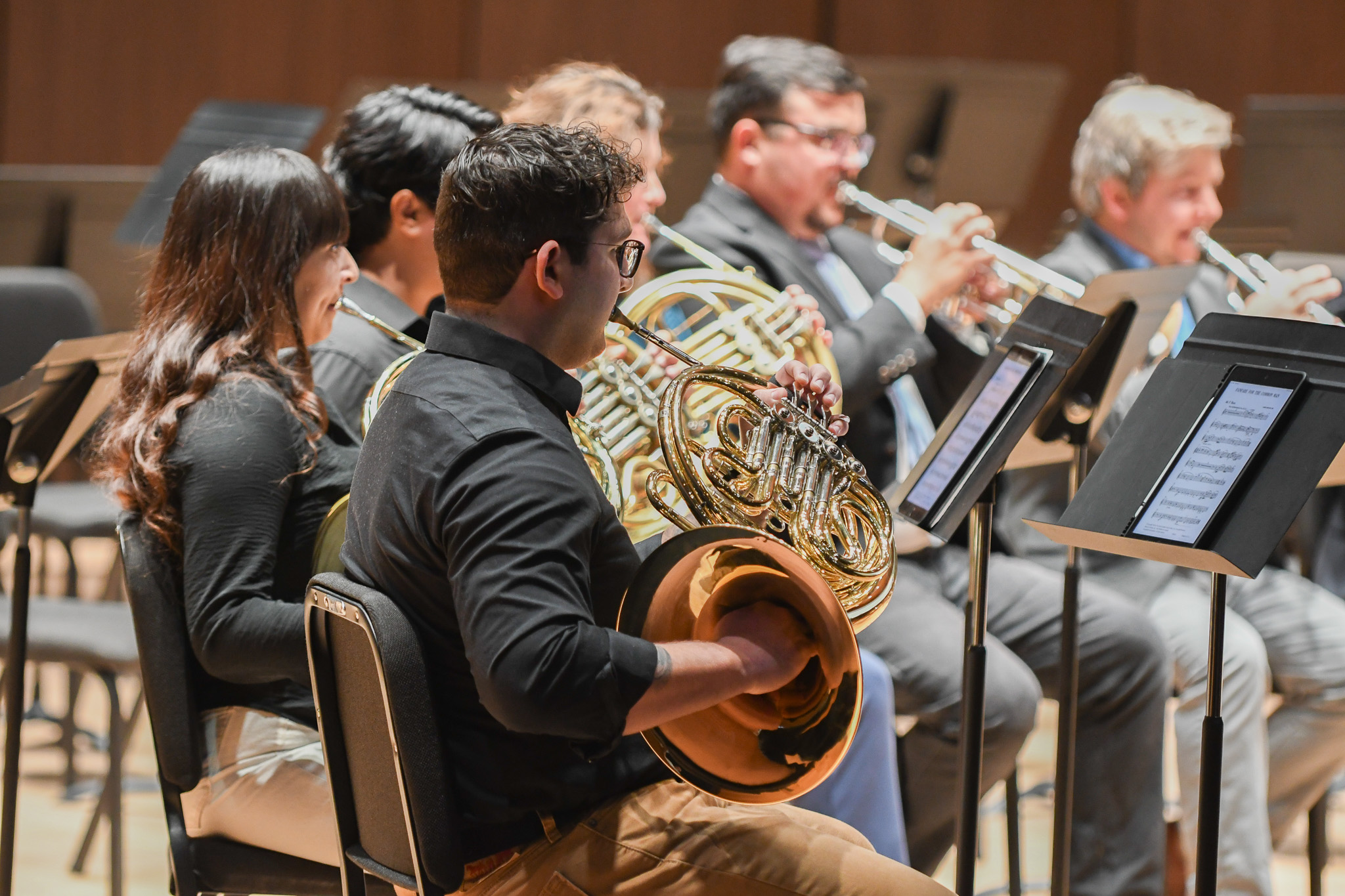 Students and faculty in a performance playing brass.