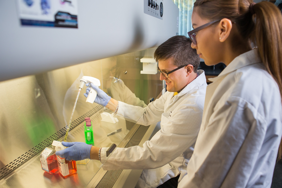 Professor guiding student on lab work
