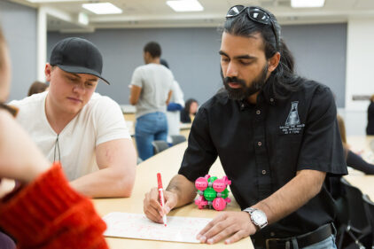 Students illustrating on a whiteboard for a robotics project.