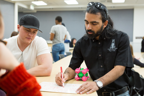 Students illustrating on a whiteboard for a robotics project.
