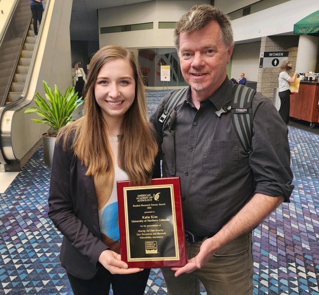 Kim Katie taking a photo with Dr. Don Finan after receiving award