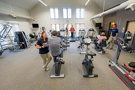 A wide shot of the rehabilitation gym with trainers and clients.