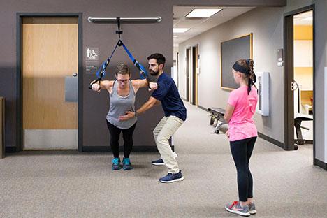 A UNC trainer helping a client with core training.
