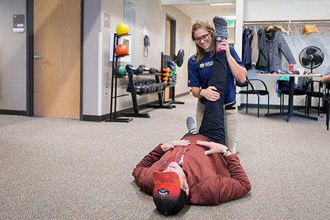 UNC trainers guiding clients in the gym.