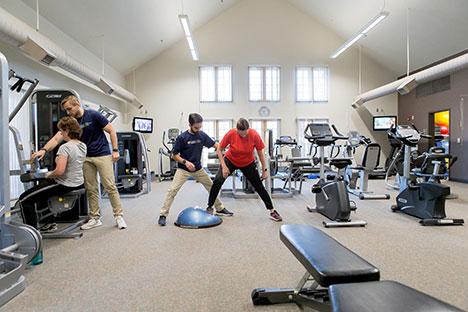 A client in a gym working with a trainer.